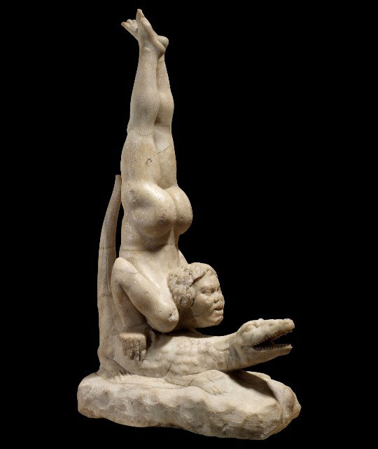 Marble statue of an acrobat on a crocodile.