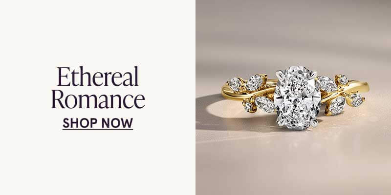 Oval diamond with marquise-cut diamonds arranged like leaves  twisting on vine-like gold band. Ethereal Romance. Click here to shop now