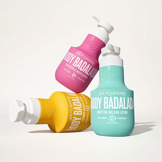 Three colorful Sol de Janeiro lotion bottles with pump dispensers are arranged artfully against a plain background.