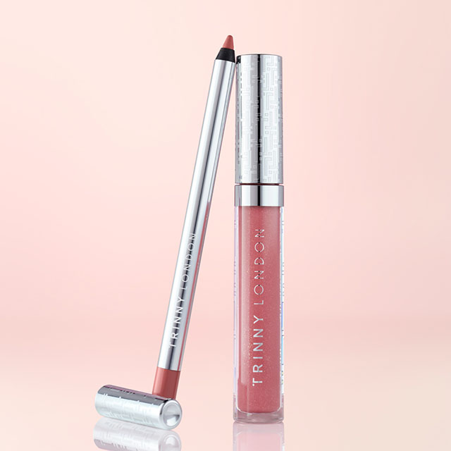 A lip pencil and lip gloss in metallic packaging against a pink background.