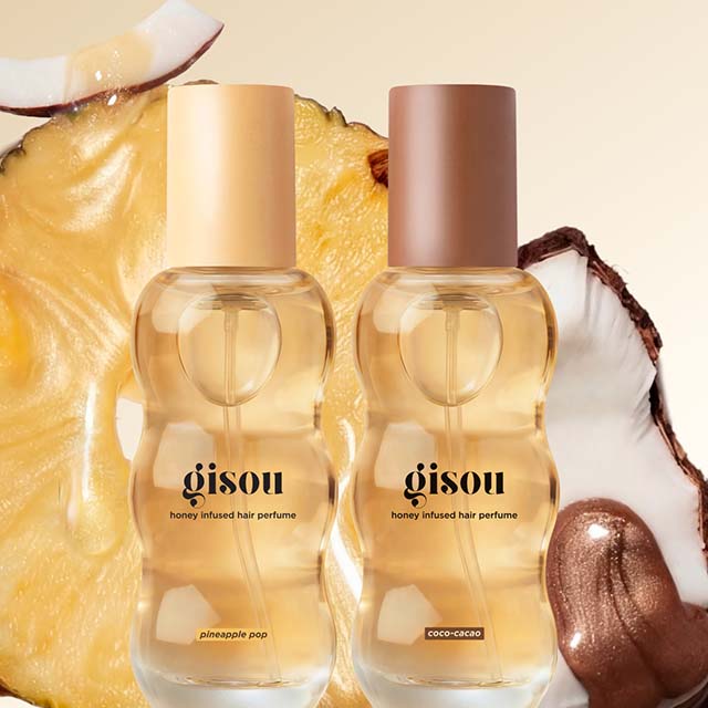 Two bottles of Gisou honey-infused hair perfume, 'Pineapple Pop' and 'Coco-Cacao,' set against a pineapple and coconut background.