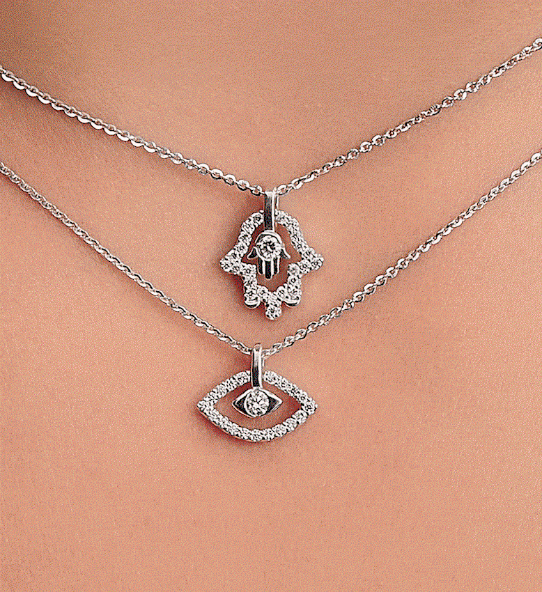 Hamsa hand and evil eye lab-grown diamond necklaces, stacked on model