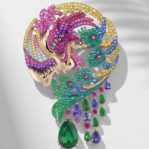 A phoenix-shaped brooch in Ethical rose gold and titanium intertwines emeralds with multicolored sapphires.