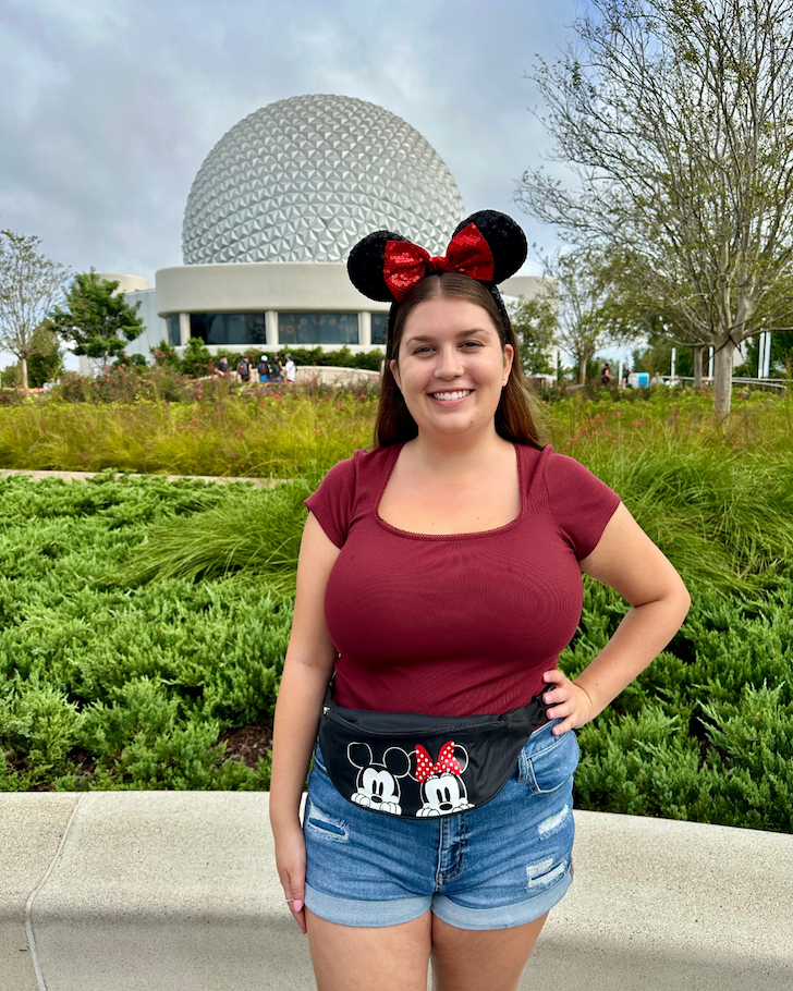 Woman wearing Peeking Mickey Mouse and Minnie Mouse Fanny Pack in front of the Epcot ball
