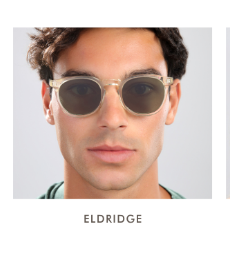A headshot of a man wearing the Eldridge (standard size) in a translucent champagne frame with dark green lenses.