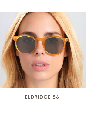 A headshot of a blonde woman wearing the Eldridge 52 (the large size) in a translucent honey-amber frame with dark lenses.