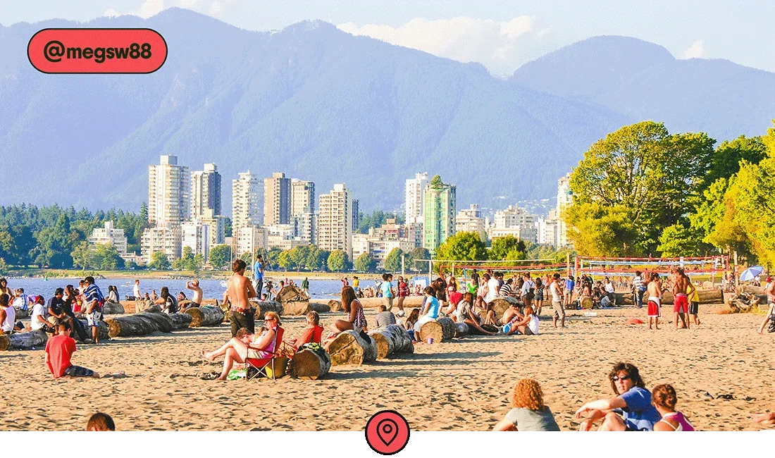 Image description: People sitting, walking, and playing volleyball on a beach along the Vancouver harbor, photo taken by @megsw88