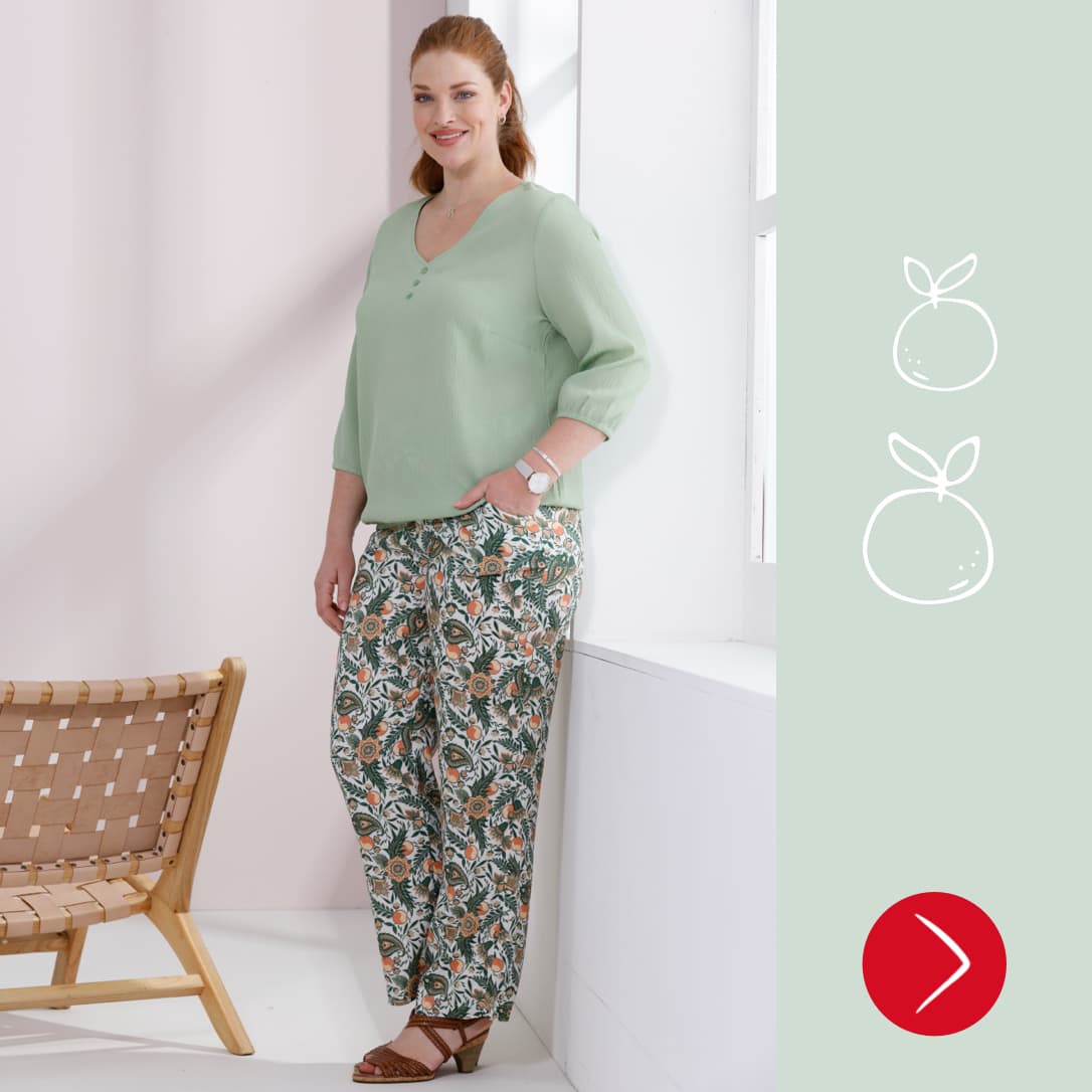  Een model draagt een muntgroene trui en een wijde broek met patroon.
