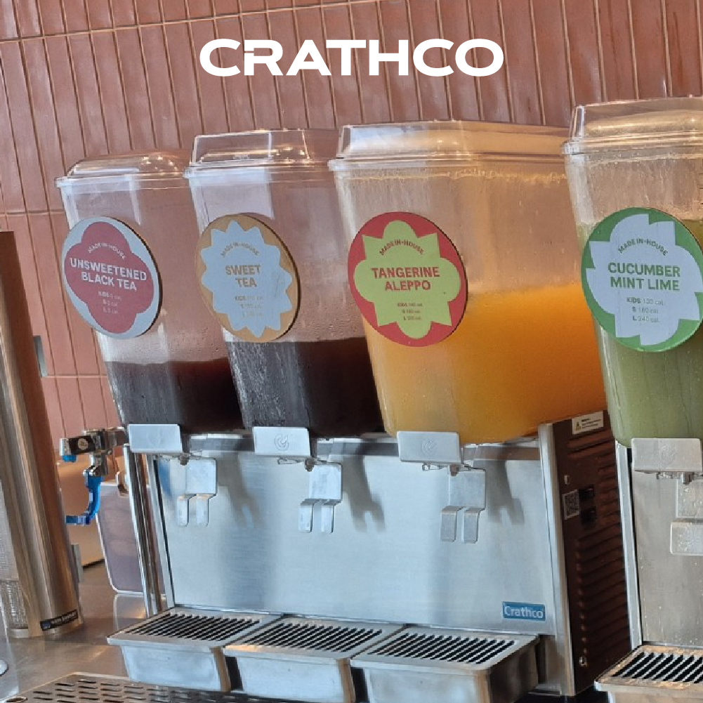 Crathco multi‑tank beverage dispenser serving assorted drinks including iced tea, tangerine aleppo, and cucumber mint lime juice in a commercial setup.