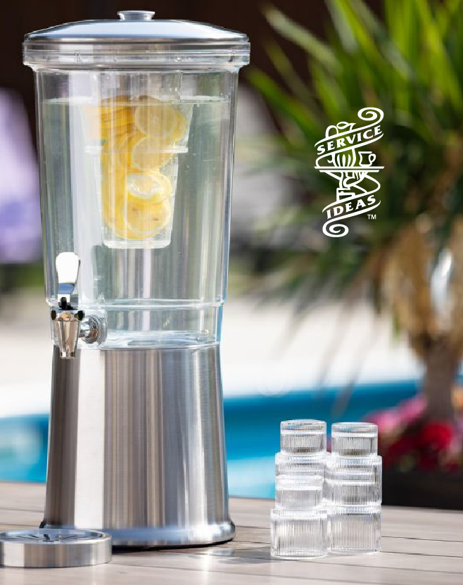 Service Ideas infused beverage dispenser filled with water and lemon slices, displayed on a tabletop with stacked clear cups in an outdoor setting.
