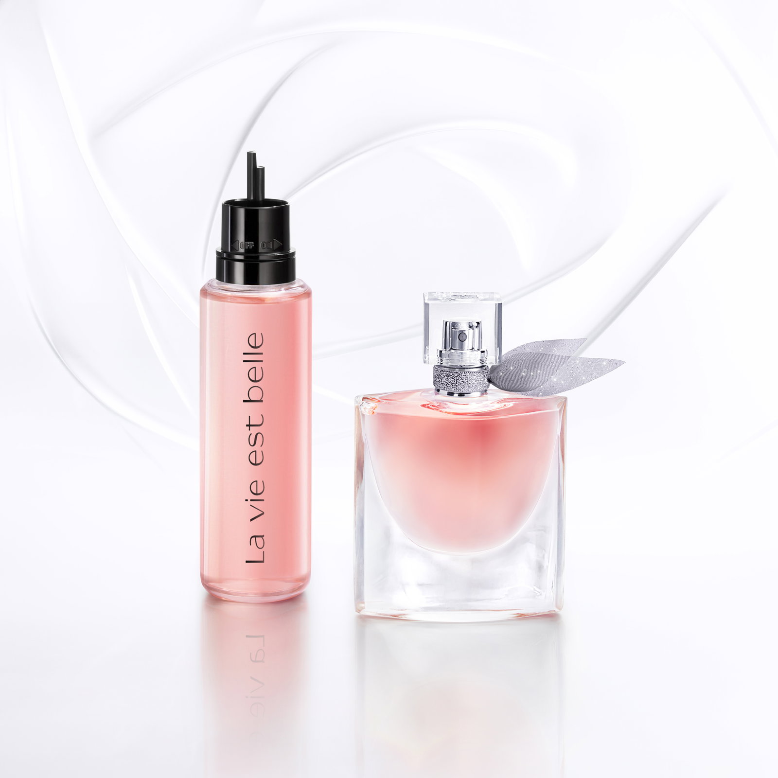 Profumo Lancôme La vie est belle: flacone eau de parfum e ricarica rosa in vetro con tappo nero su sfondo bianco