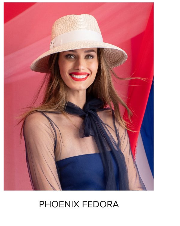 Woman wearing a stylish fedora hat and a sheer top with a bold red lip.