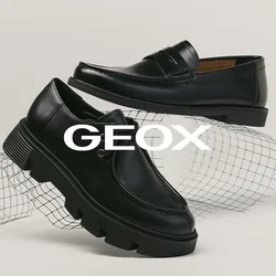 Twee zwarte leren schoenen op een witte ondergrond, één loafer met stiksels en één veterlaars met een dikke zool, geplaatst boven een gebogen draadgaas.