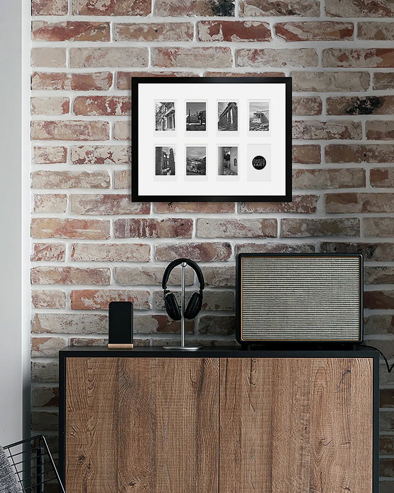 Black multi-photo Instax frame mounted on exposed brick wall