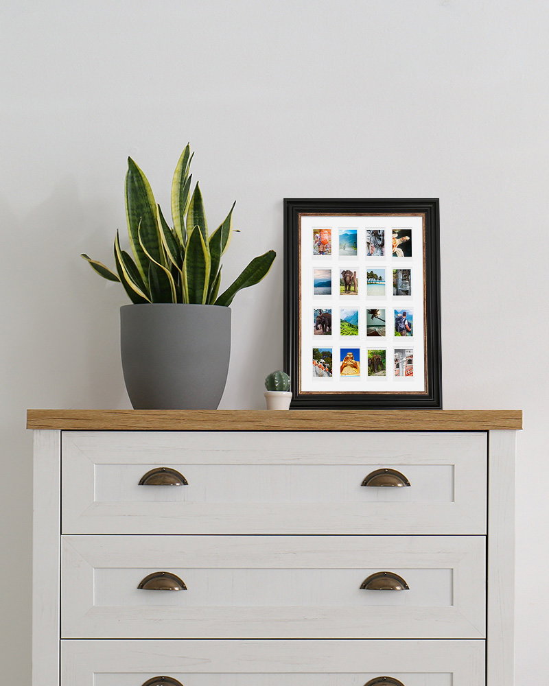 Black Instax collage frame displayed on white chest of drawers