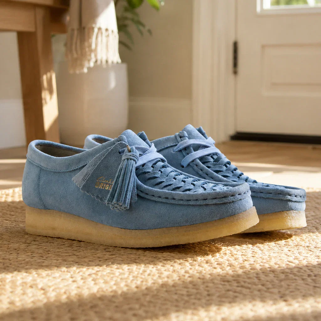 Clarks Women's blue suede platform wallabee shoes with crepe sole on beige carpet in bright hallway.