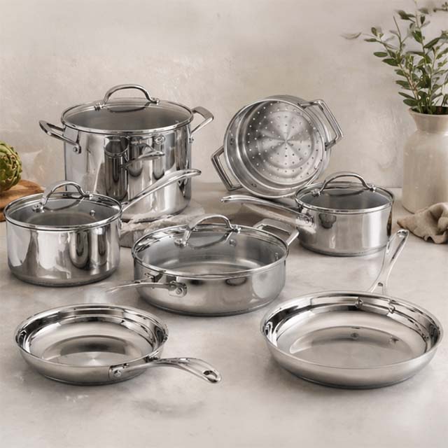 Stainless steel Stellar cookware set with pots, pans, and lids on a kitchen counter.