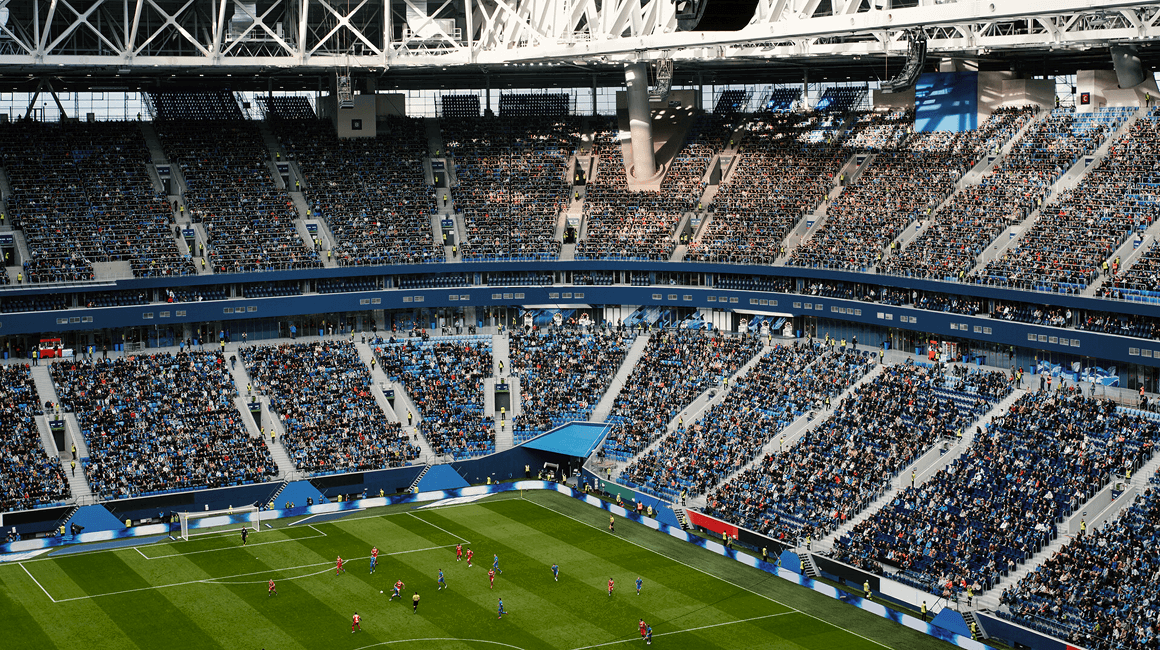 A sports stadium full of fans watching a soccer game.