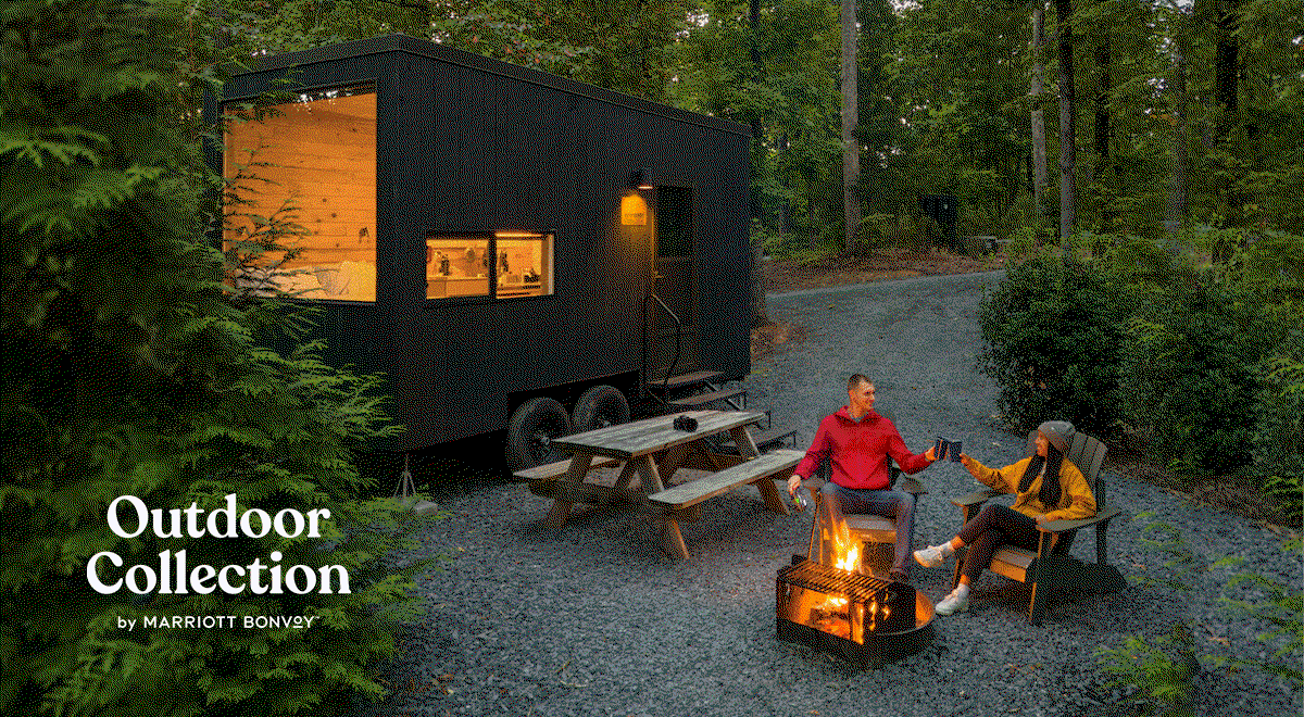 A couple sitting outside by a firepit at an Outdoor Collection by Marriott Bonvoy property.