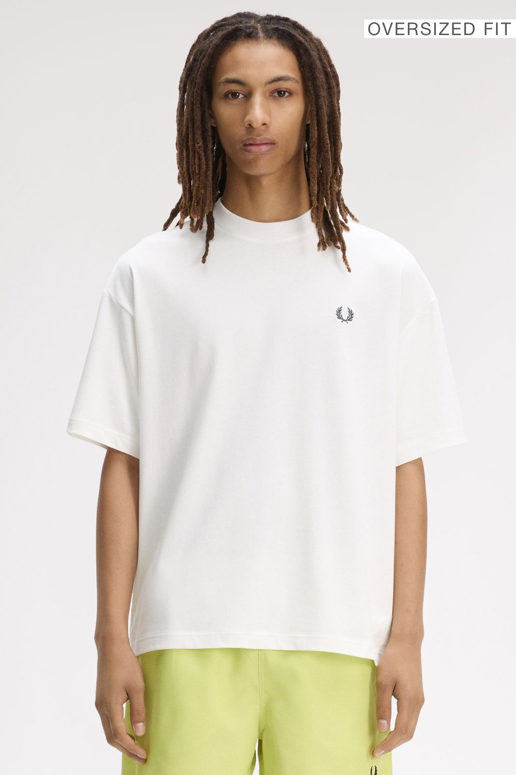 A male model wearing a Fred Perry Back Print Laurel Wreath Oversized T-Shirt in Snow White