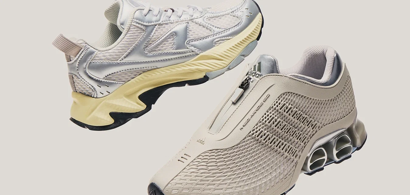 Een paar lichtgekleurde sportschoenen, de ene met een rits en netdesign, de andere met veters en een dikke zool, tegen een effen achtergrond.