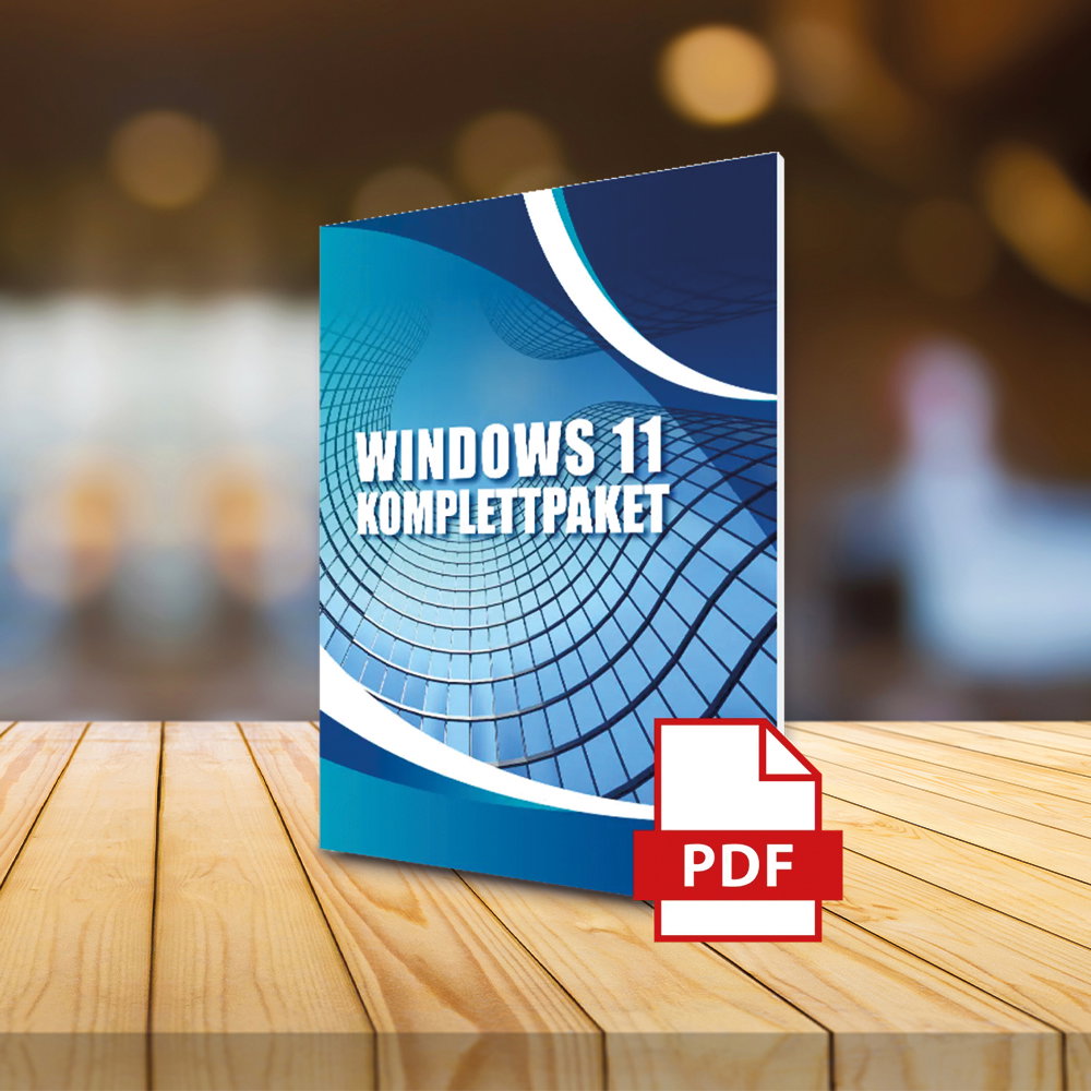 Buchcover mit der Aufschrift 'WINDOWS 11 KOMPLETTPAKET' und einem roten PDF-Symbol auf einem Holztisch vor unscharfem Hintergrund