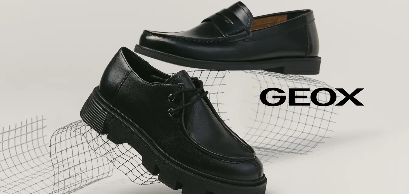 Twee zwarte leren schoenen op een witte ondergrond, één loafer met stiksels en één veterlaars met een dikke zool, geplaatst boven een gebogen draadgaas.