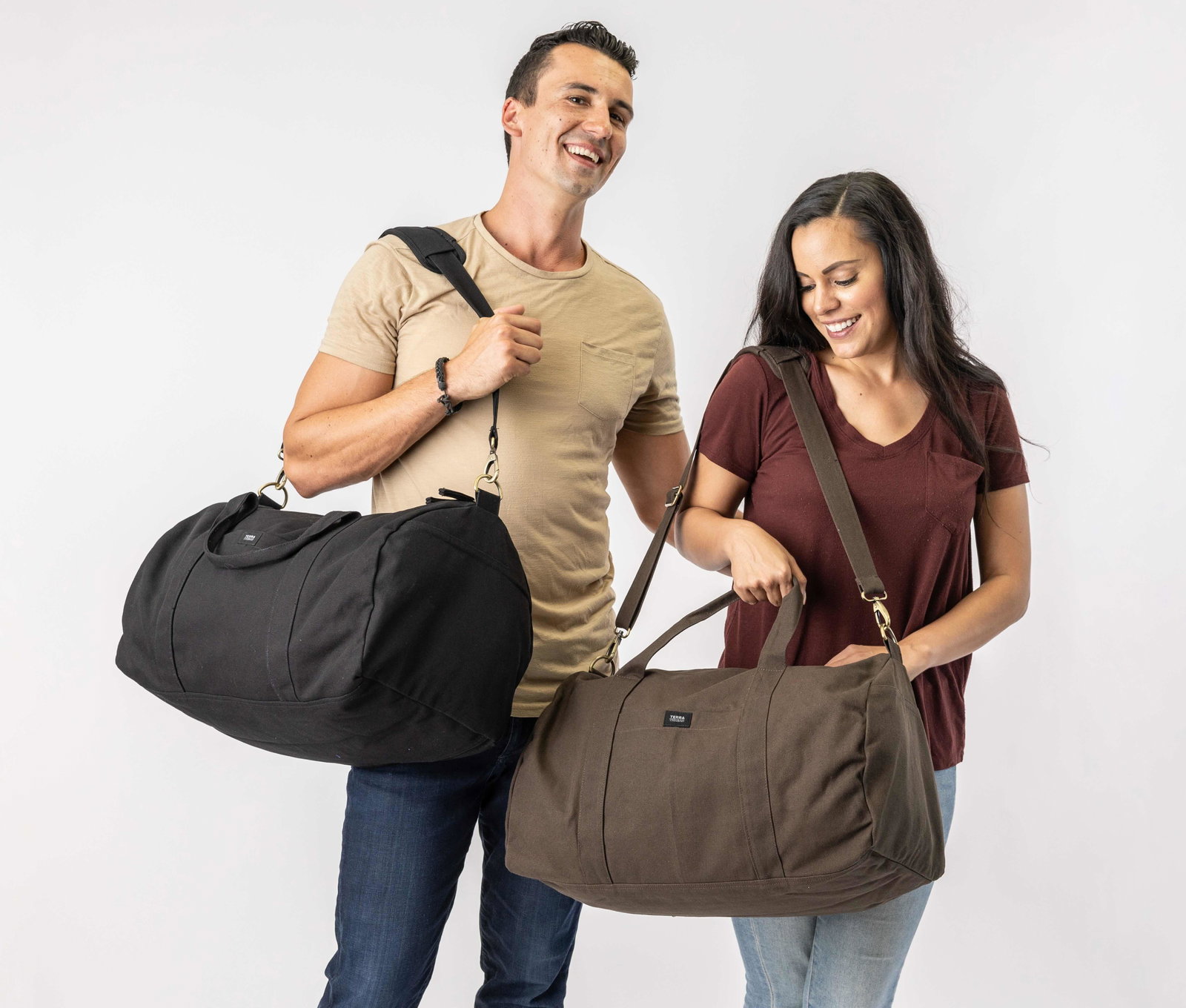 organic cotton duffel bags in black and brown color carried by a man and woman