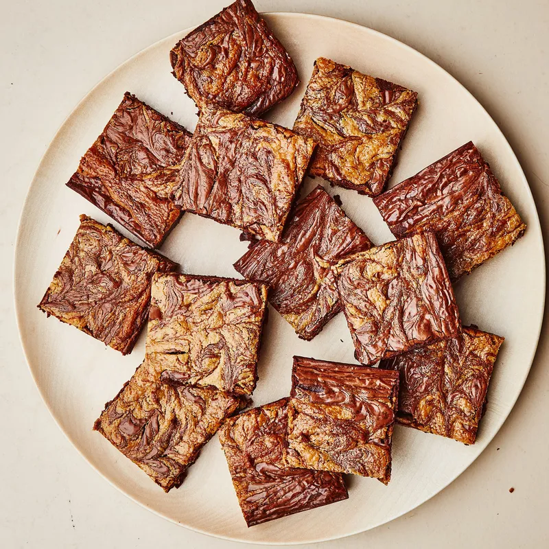 Square slices of gluten-free chocolate-tahini brownies on a plate.