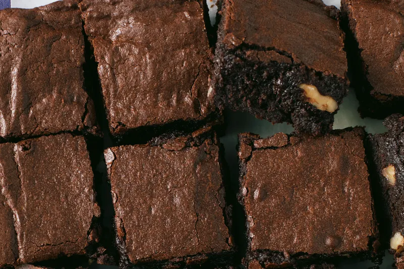A grid of cocoa brownies with walnuts.