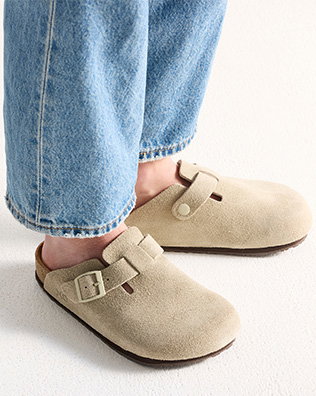 Person som bär ljusbeiga mockasandaler med täckt tå