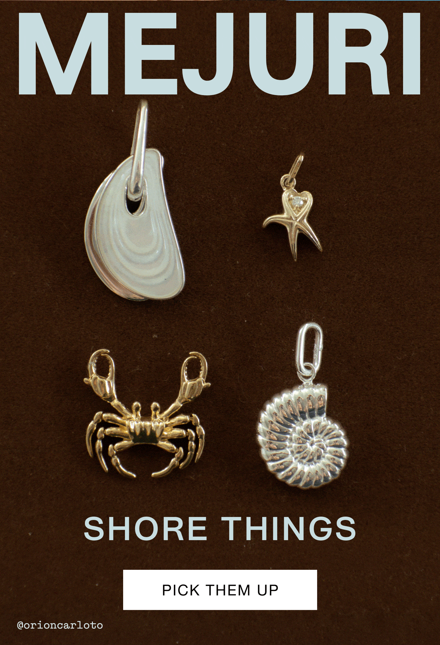 Mejuri Shore Things collection — four ocean-inspired charms displayed on a dark brown background: a silver mussel shell pendant, a gold starfish charm with a diamond heart detail, a gold crab charm, and a silver nautilus shell pendant. Text reads "Shore Things" with a "Pick Them Up" call-to-action button.