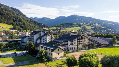 Hotel von außen im Sommer inmitten der Berge