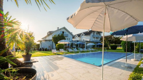 Hotel Außenansicht mit Pool, Liegen und Sonnenschirmen