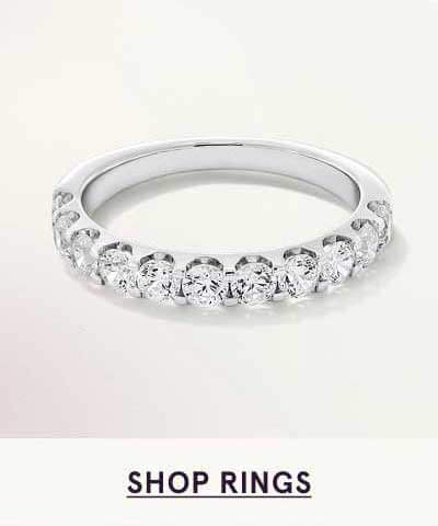 Silver eternity-style band featuring row of round diamonds in shared-prong setting. Click here to shop rings