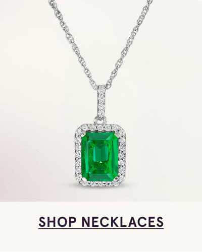 Emerald-cut green gemstone, framed by diamond halo on silver link chain. Click here to shop necklaces