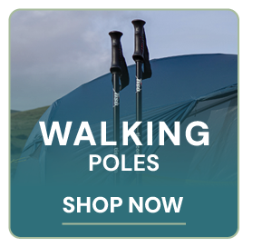 WALKING POLES. Two walking poles stick out of the ground, tent visible in the background. 