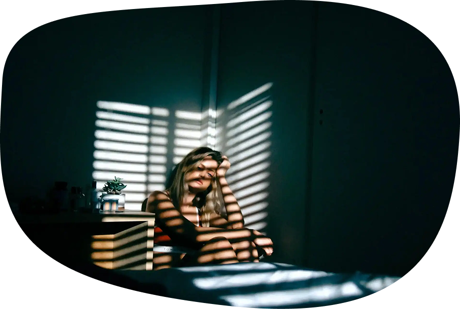 Image: Person in room with hand on head, thinking