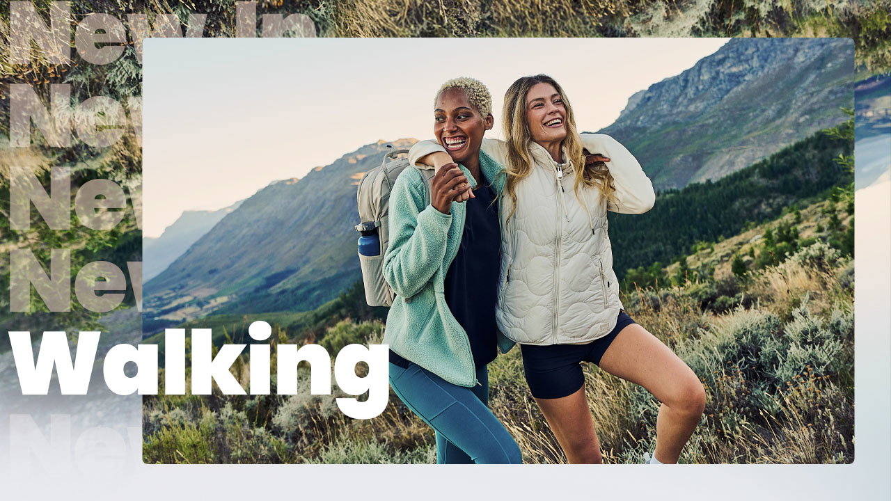 Two female walkers laughing and having a great time walking in the hills.