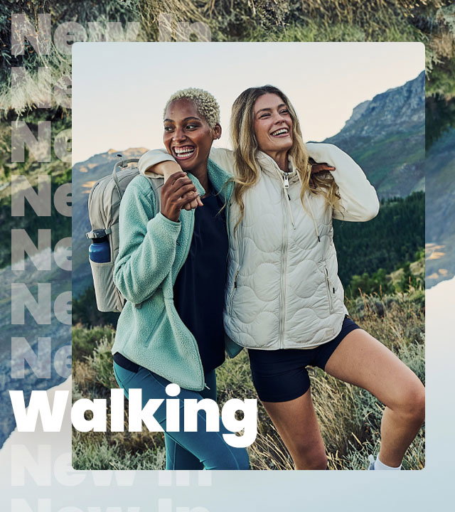 Two female walkers laughing and having a great time walking in the hills.