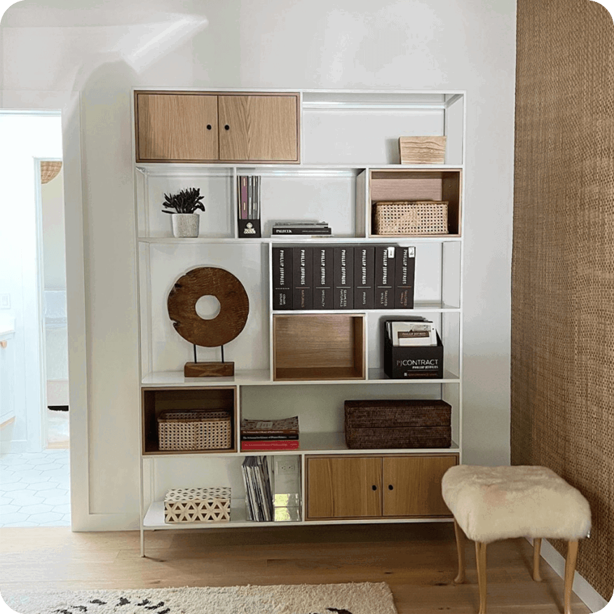 White Foshay bookcase with wood doors and shelves holding books, baskets and decor.