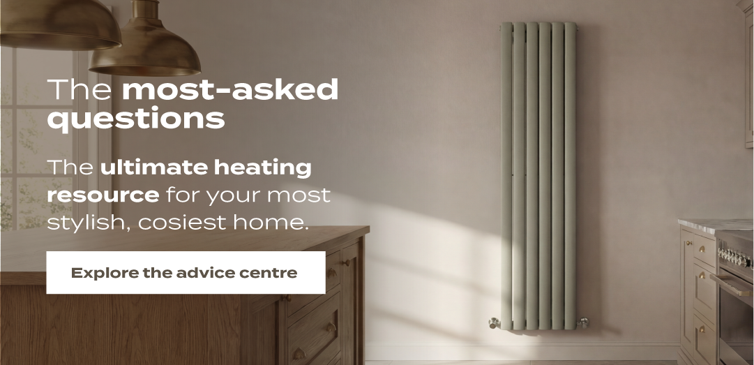 Soft green vertical radiator in a warm neutral kitchen interior with wooden cabinetry and natural sunlight.
