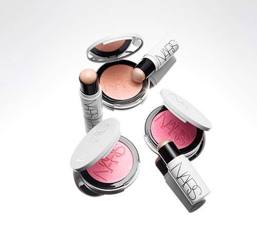 Various NARS makeup products, including compact blushes in pink and peach shades, and matching lipsticks with white and silver packaging, arranged on a white background.