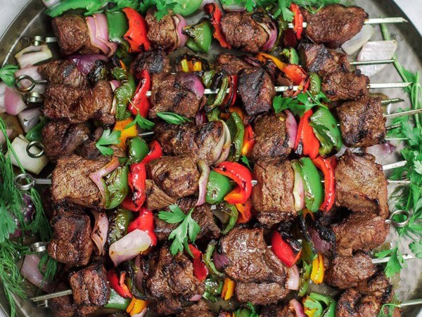 Grilled shish kabobs on a platter.