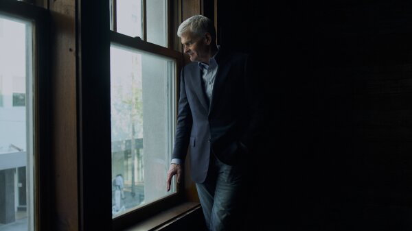 Sen. Bill Cassidy standing and looking out of a window. 