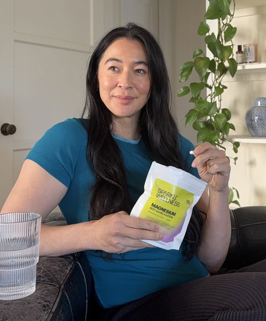 Meagan Kong sitting at her kitchen table drinking coffee mixed with Advanced 4-In-1 Boost. Shop now. 