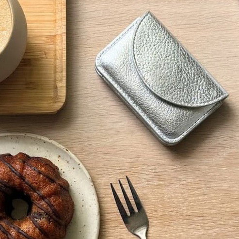 silver wallet on table with cake