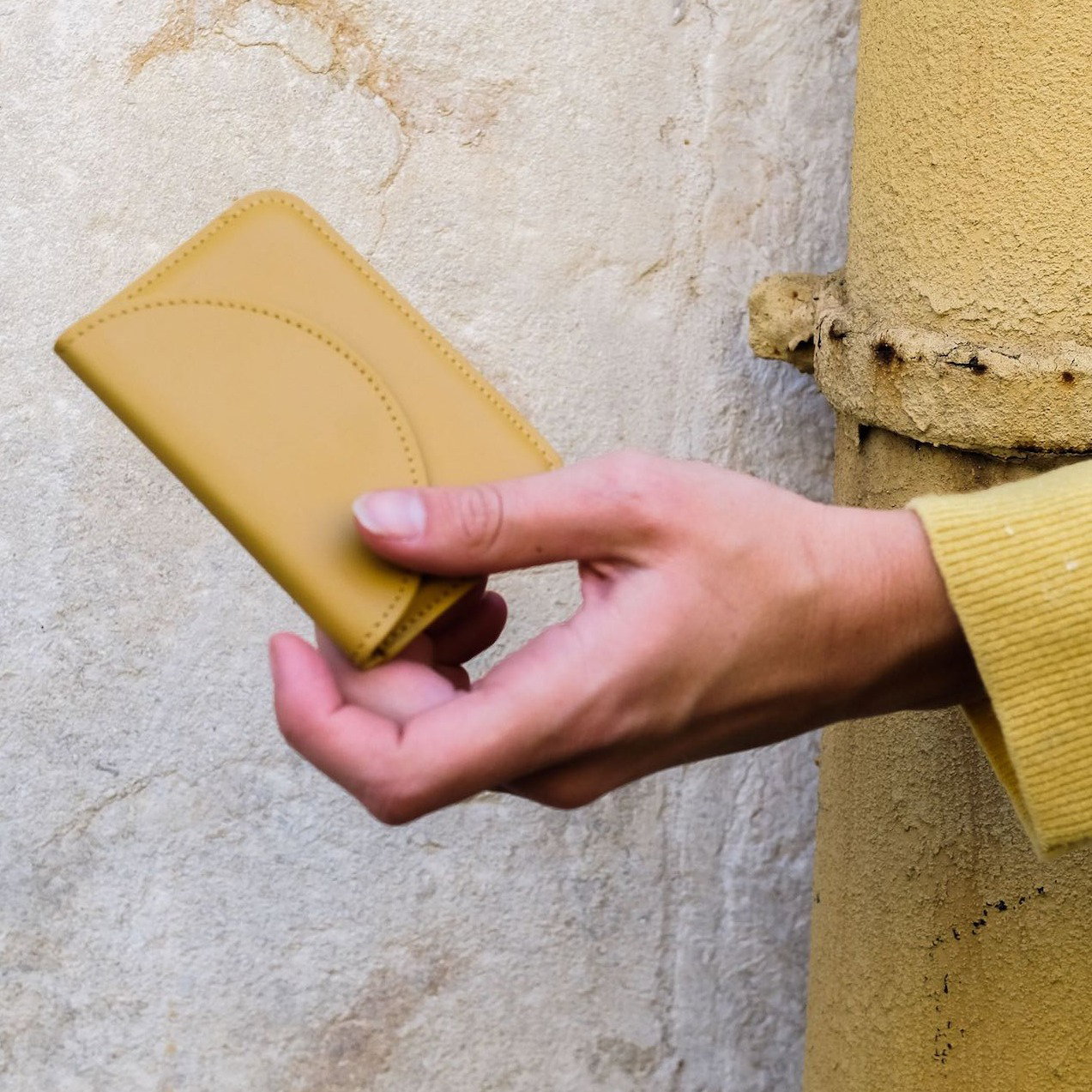 Curry color wallet held in hand
