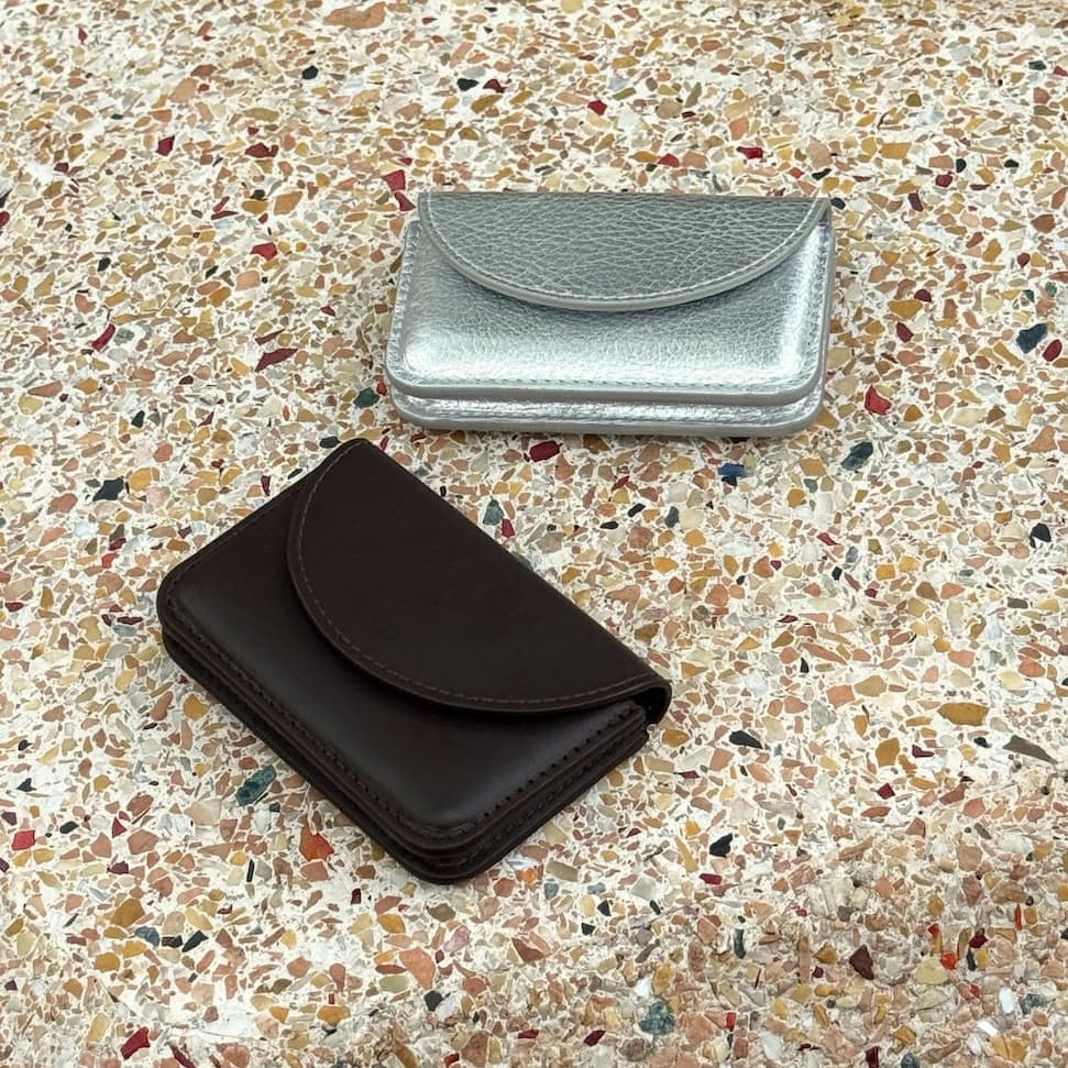brown and silver leather wallets on a terrazzo sculptor