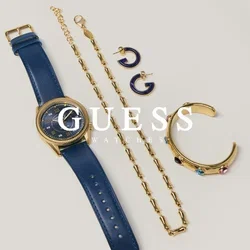 Montre à bracelet en cuir bleu, collier chaîne en or, bracelet manchette en or avec pierres colorées, et deux petites boucles d'oreilles créoles bleu et or sur fond gris.